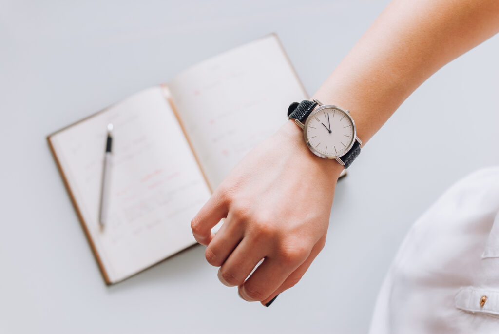 Woman Wearing A Watch With Notebook Blurred In Background